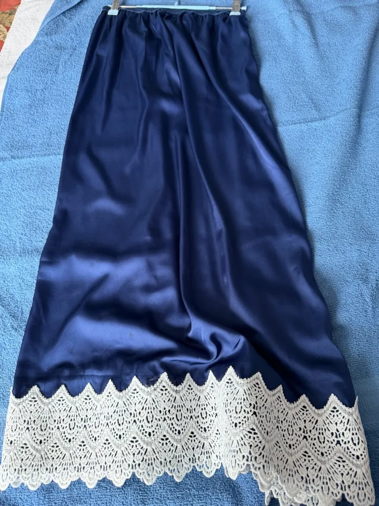 Full view of handmade lingerie in breathable navy blue satin with a bold, white geometric lace hem.