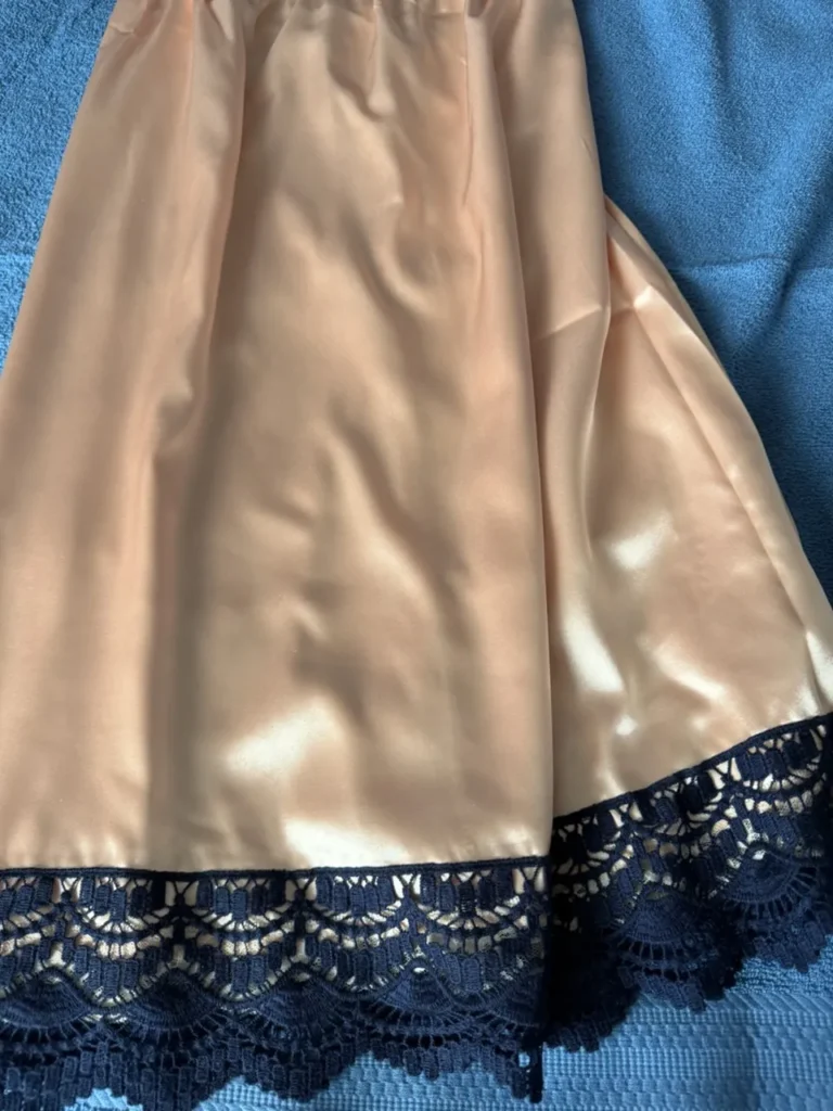 Handmade lingerie featuring breathable champagne satin fabric and detailed navy blue lace trim.